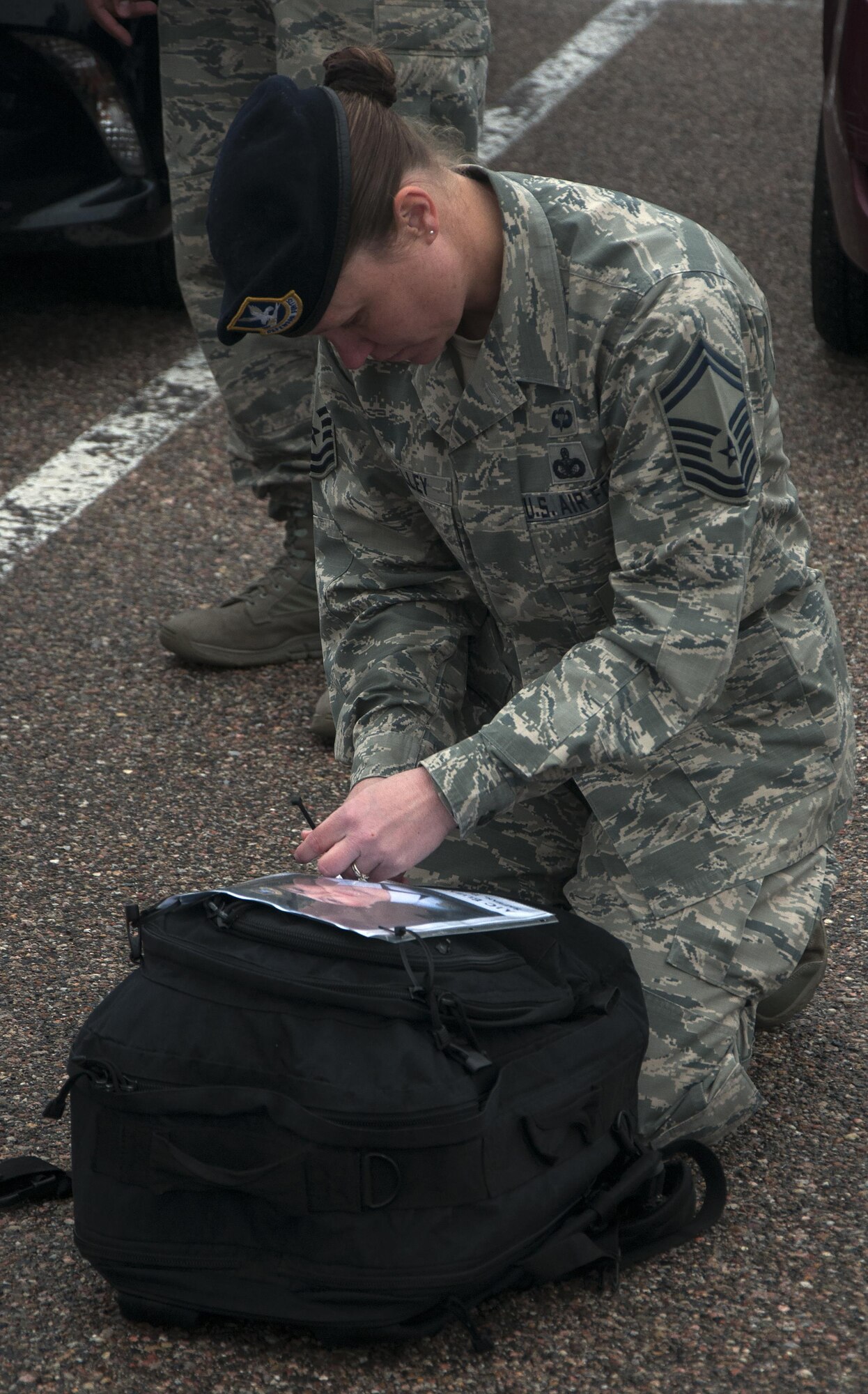 Senior Master Sgt. Rebecca McNelley, 90th Security Forces Squadron, pins a photo of a fallen defender to her back-pack May 6, 2016,  before participating in a memorial 5-kilometer ruck-run in honor of National Police Week on F.E. Warren Air Force Base, Wyo. Each member who participated in the ruck portion of the event carried a photo of a fallen comrade. (U.S. Air Force photo by Senior Airman Brandon Valle)