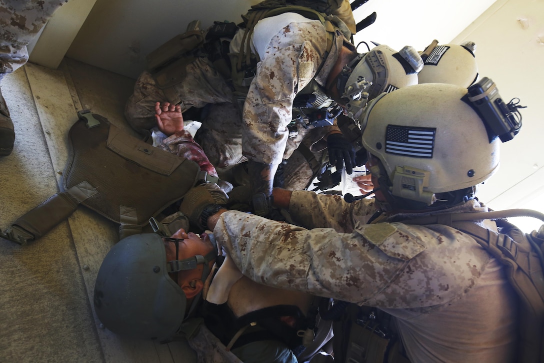 Marines triage and set a tourniquet onto a simulated casualty, as fake blood leaks from a prosthetic device while conducting a raid during the 11th Marine Expeditionary Unit’s field exercise aboard Marine Corps base Camp Pendleton, Calif., May 12, 2016.  Tourniquets are used to constrict an extremity, controlling excessive bleeding and serve as a means of treating life-threatening hemorrhages in combat. The Marines are with Maritime Raid Force, 11th MEU. (U.S. Marine Corps photo by Sgt. Xzavior McNeal/Released)
