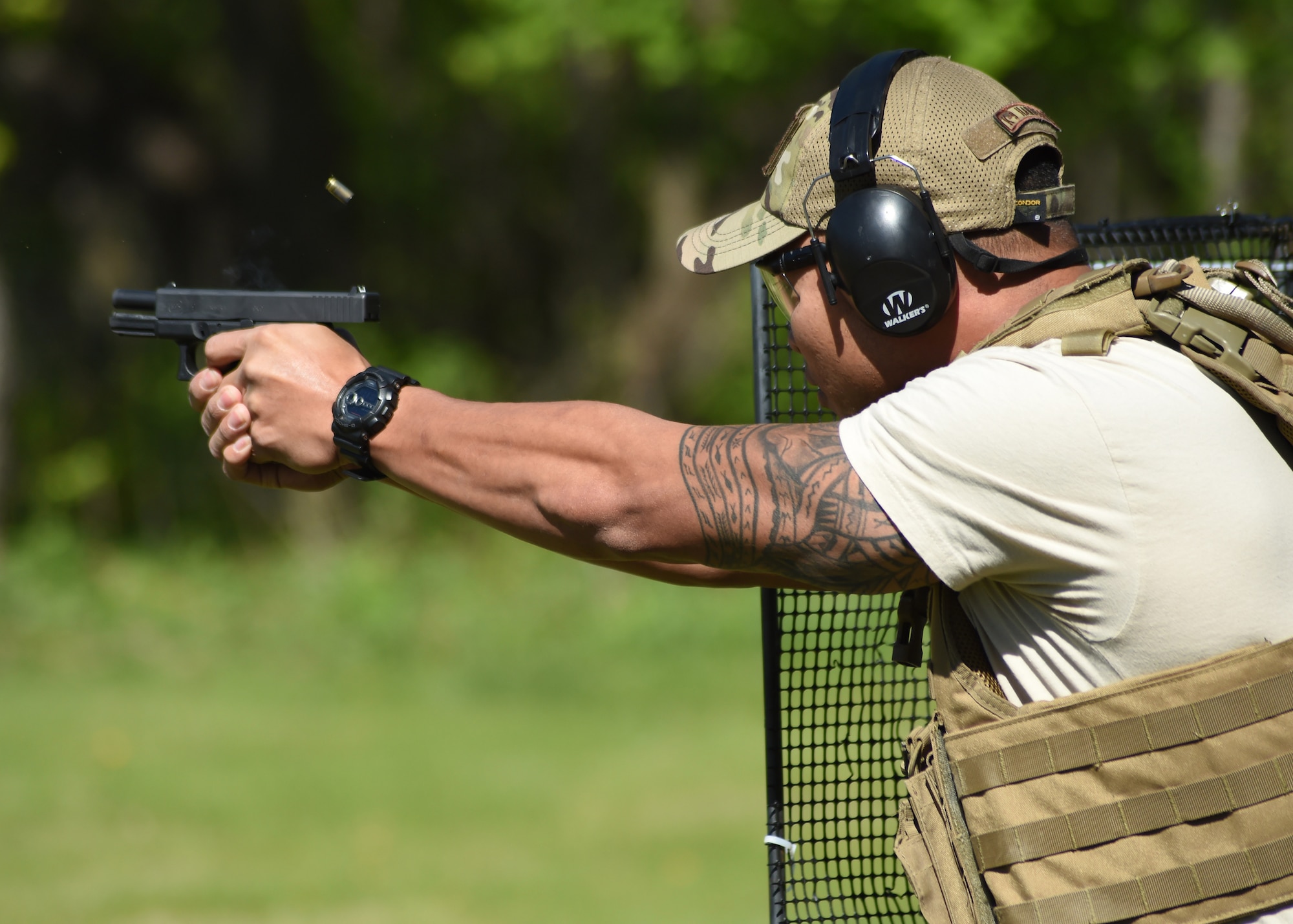 U.S. Air Force Staff Sgt. Jesse Aquino, 319th Security Forces Squadron military working dog handler, fires a pistol May 15, 2016, in East Grand Forks, Minn. Aquino was one of several Airmen to participate in a joint shooting competition held at the East Grand Forks Rod and Gun Club in honor of National Police Week. (U.S. Air Force photo by Airman 1st Class Ryan Sparks/Released)