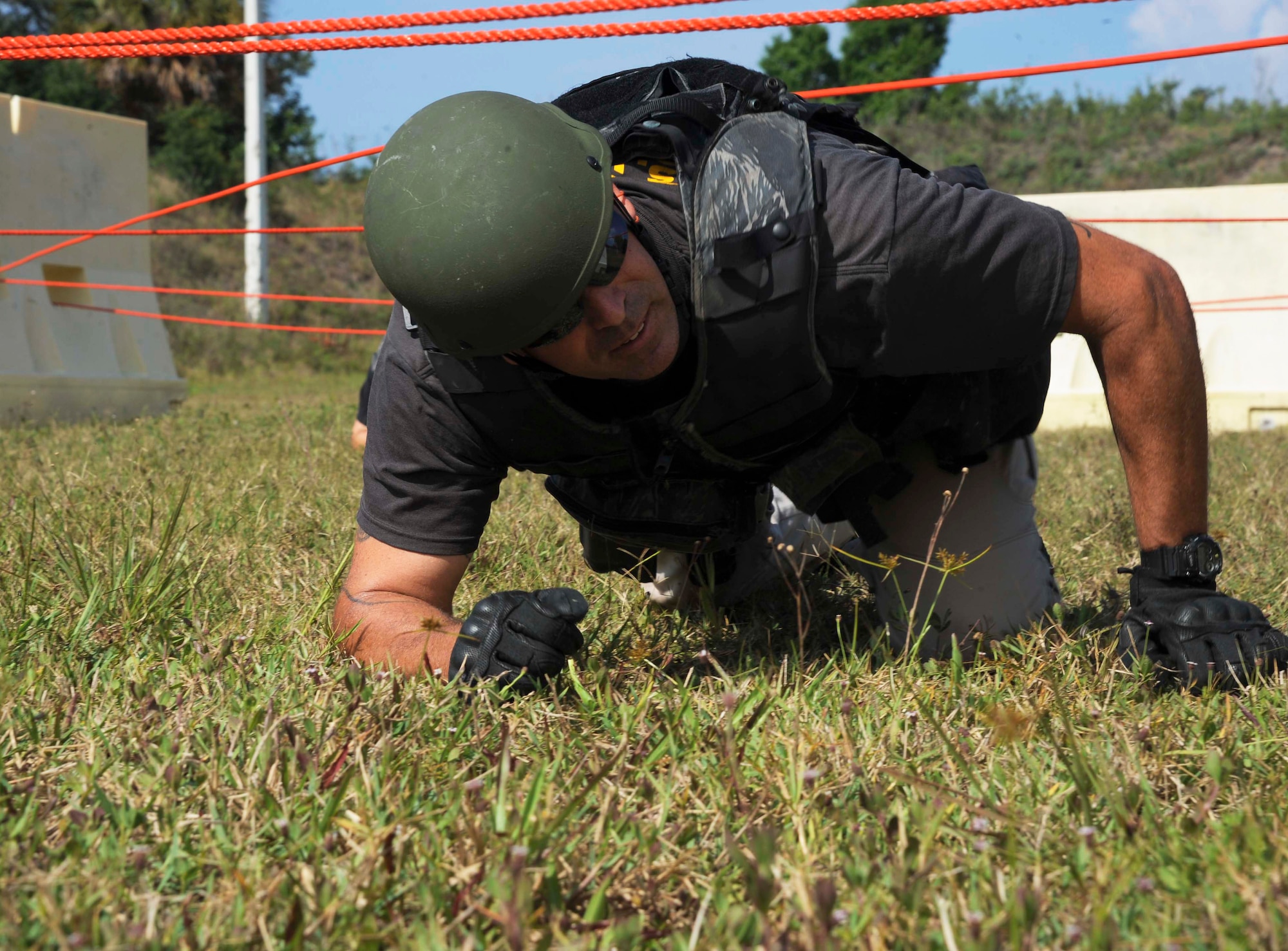 An officer from the Clearwater special weapons and tactics team low-crawls under a rope obstacle during the third annual tactical competition, May 13, 2016 at MacDill Air Force Base, Fla. The competition was held for National Police Week, which honors the sacrifice of law enforcement officers. (U.S. Air Force photo by Airman Adam R. Shanks)