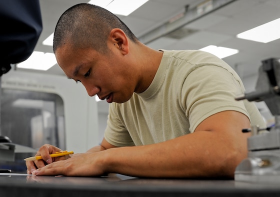 Staff Sgt. Armand Guting, an aircraft metals technology technician with the 6th Maintenance Squadron, draws a blueprint for a customized paint rack at MacDill Air Force Base, Fla., May 13, 2016. Blue prints are created before a part or product is fabricated. (U.S. Air Force photo by Airman 1st Class Mariette Adams)