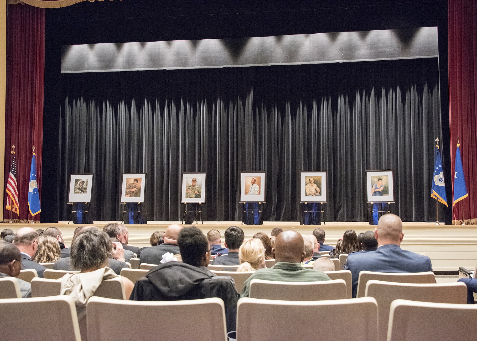 Family members of the six Fallen Heroes killed Dec. 21, 2015, by a suicide bomber near Bagram Air Field, Afghanistan, view the portraits of their departed loved ones during the unveiling ceremony May 16 at the Little Hall Auditorium, Marine Corps Base Quantico, Va. The portraits were hung later that day in the Air Force Office of Special Investigations Headquarters Hall of Heroes. (U.S. Air Force photo/Special Agent Cameron MacKenzie)  