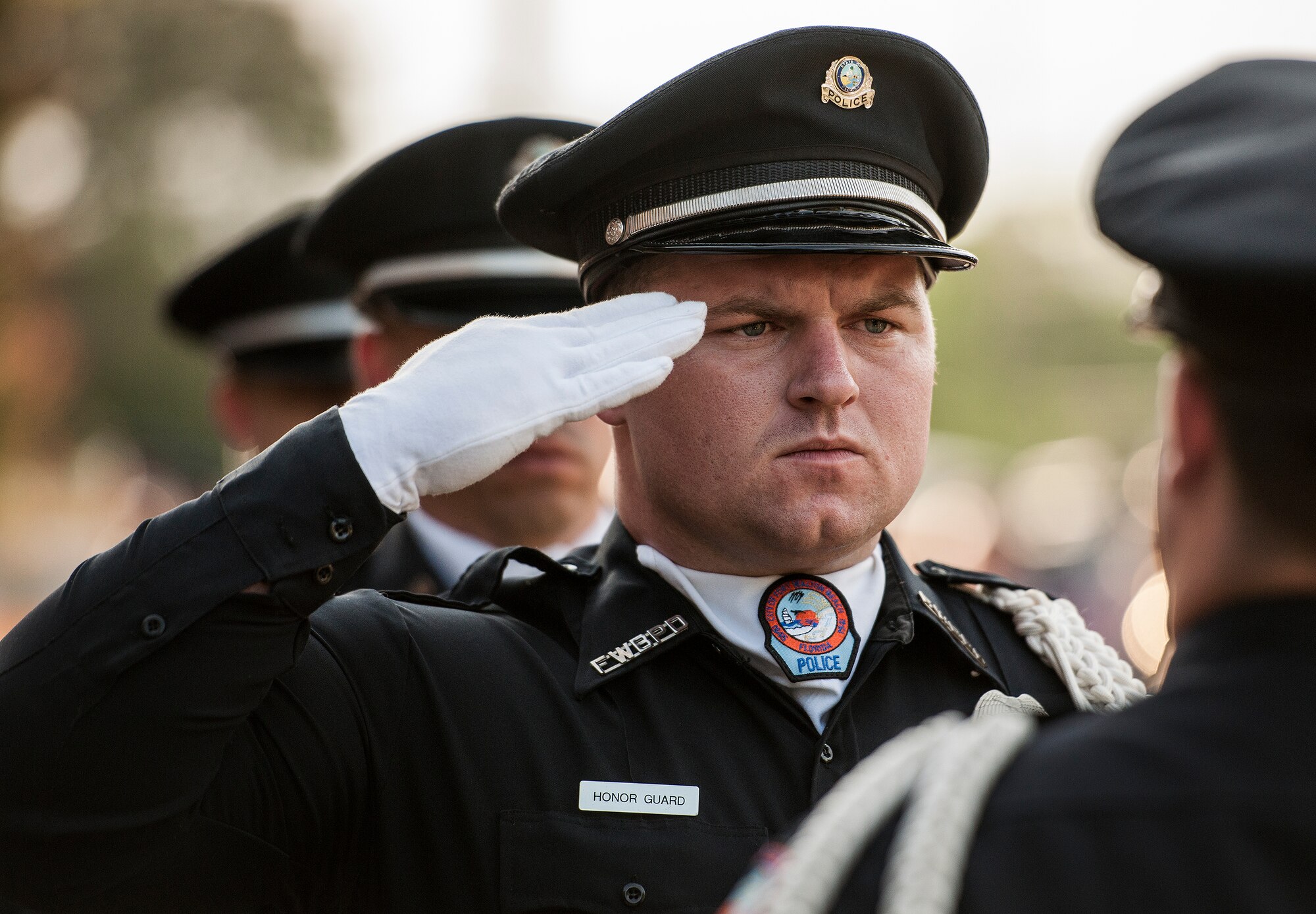 An honor guard member salutes before taking his shotgun during the Peace Officers’ Memorial Ceremony May 16 in Fort Walton Beach, Fla.  The ceremony was to honor fallen police officers from the previous year by reading their names aloud.  Security forces Airmen from Eglin and Hurlburt Field attended and participated in the event.  The ceremony is one of many events taking place during National Police Week.  (U.S. Air Force photo/Samuel King Jr.)