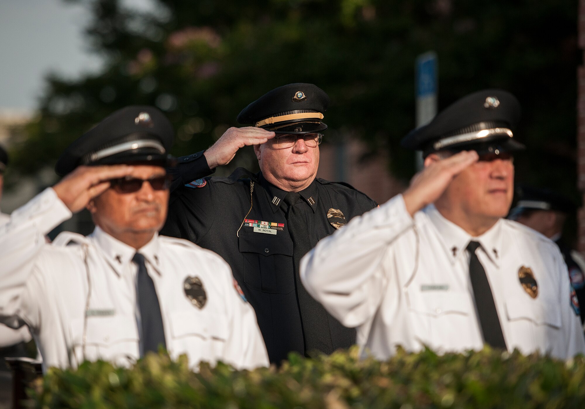 Flanked on both sides by police chaplains, Interim Chief William Royal salutes during the Peace Officers’ Memorial Ceremony May 16 in Fort Walton Beach, Fla.  The ceremony was to honor fallen police officers from the previous year by reading their names aloud.  Security forces Airmen from Eglin and Hurlburt Field attended and participated in the event.  The ceremony is one of many events taking place during National Police Week.  (U.S. Air Force photo/Samuel King Jr.)