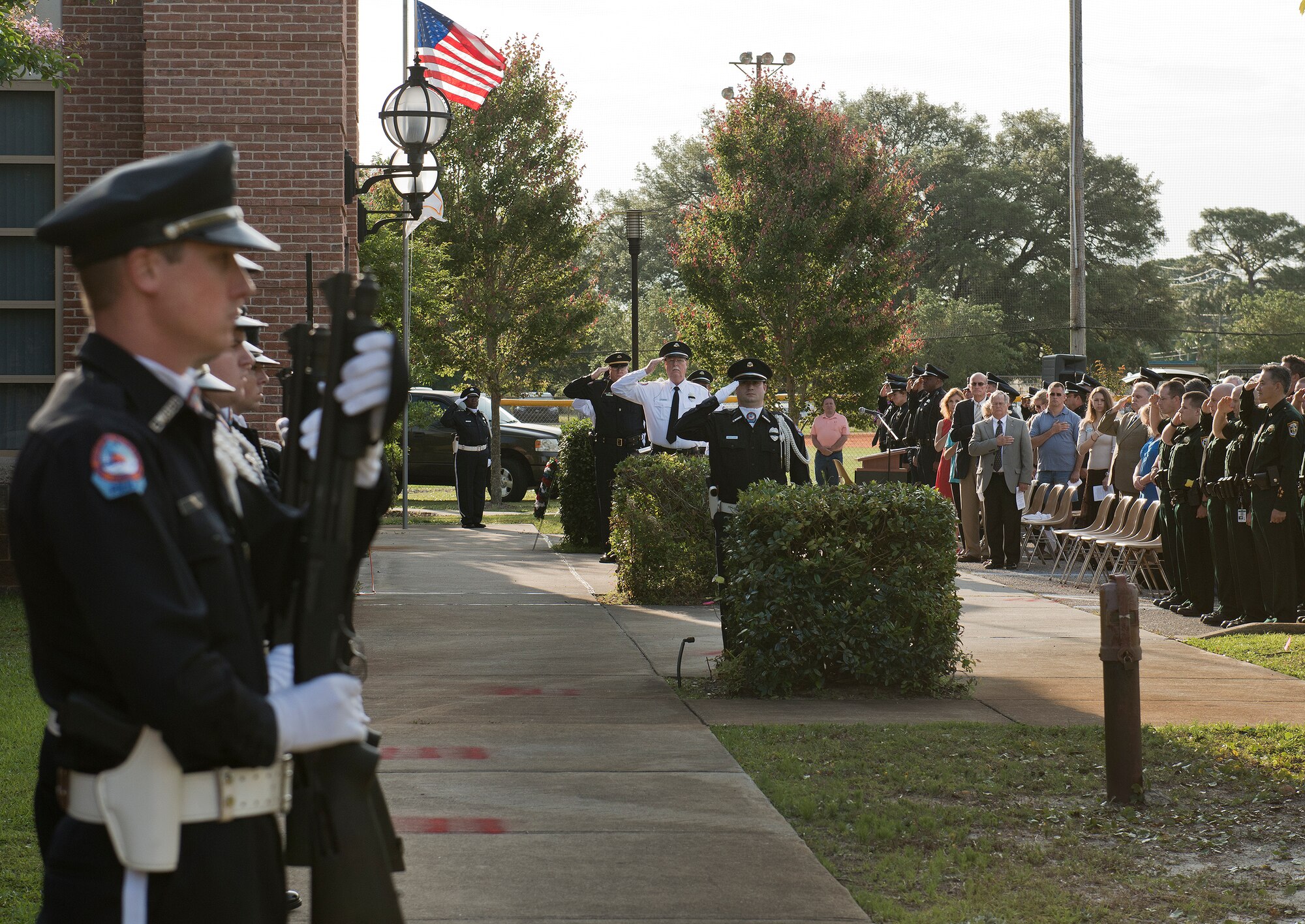 Officers and guests salute during the playing of Taps at the Peace Officers’ Memorial Ceremony May 16 in Fort Walton Beach, Fla.  The ceremony was to honor fallen police officers from the previous year by reading their names aloud.  Security forces Airmen from Eglin and Hurlburt Field attended and participated in the event.  The ceremony is one of many events taking place during National Police Week.  (U.S. Air Force photo/Samuel King Jr.)