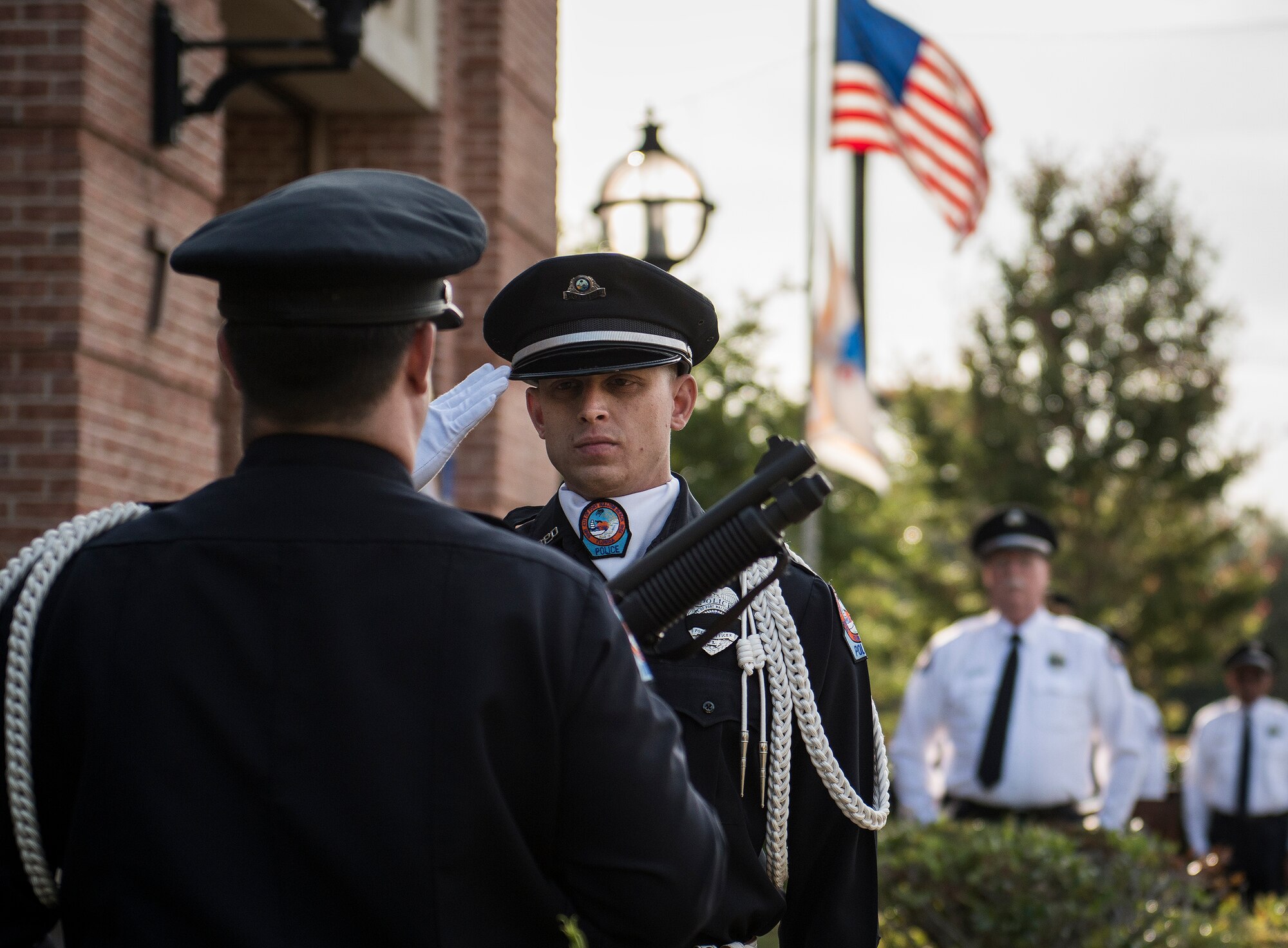 An honor guard member salutes before taking his shotgun during the Peace Officers’ Memorial Ceremony May 16 in Fort Walton Beach, Fla.  The ceremony was to honor fallen police officers from the previous year by reading their names aloud.  Security forces Airmen from Eglin and Hurlburt Field attended and participated in the event.  The ceremony is one of many events taking place during National Police Week.  (U.S. Air Force photo/Samuel King Jr.)