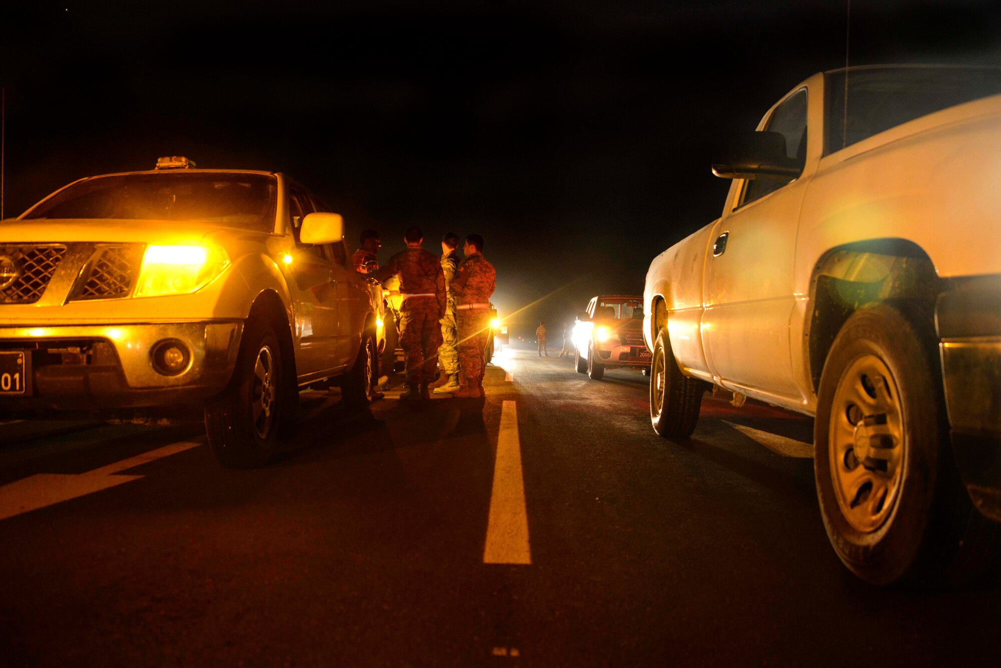 Members of the force protection team escort contractors into the flight line May 11, 2016, at Al Udeid Air Base, Qatar. In order for civilian contractors to work on base, force protection Airmen must be present to ensure safety and security violations do not occur. (U.S. Air Force photo/Senior Airman Janelle Patiño/Released)