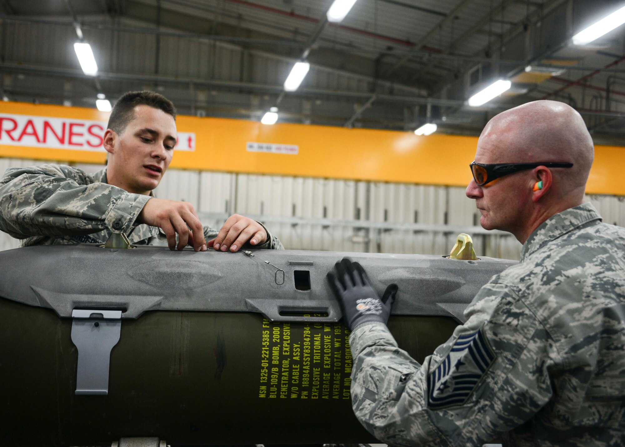 Airman First Class Tyler Anderson, 379th Expeditionary Maintenance Squadron Munitions Flight conventional maintenance crew member, teaches Chief Master Sgt. Thomas Good, 379th Air Expeditionary Wing command chief, about the fuze unit-63 initiator for a guided bomb unit May 10, 2016, at Al Udeid Air Base, Qatar. An FZU-63 initiates the explosive train from the GBU once it is released from the aircraft. (U.S. Air Force photo/Senior Airman Janelle Patiño/Released)