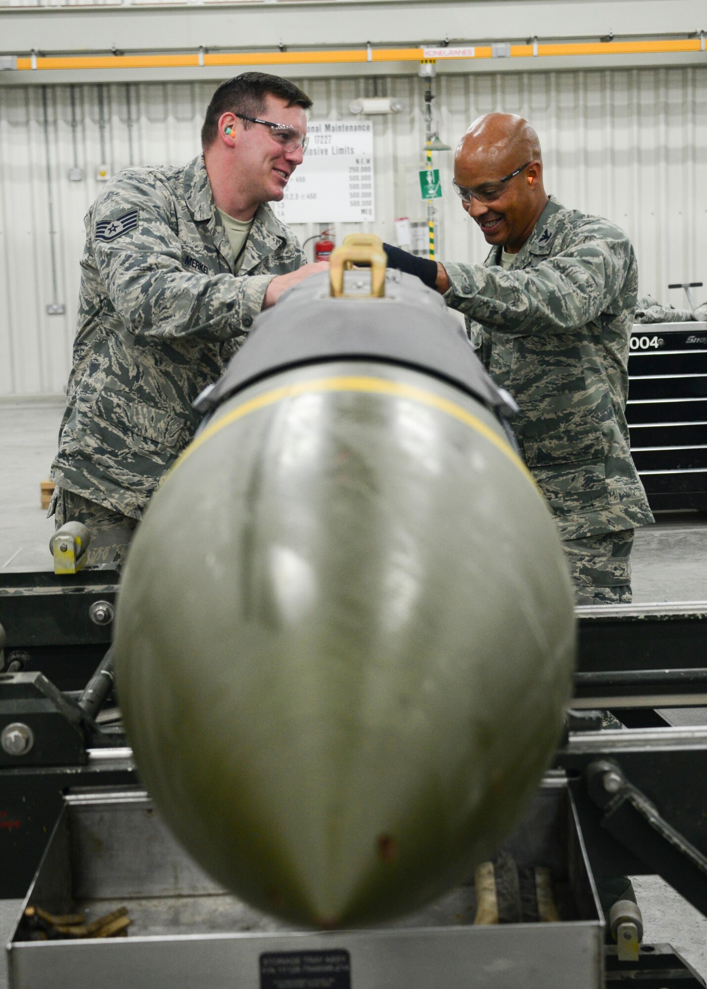 Staff Sgt. Kevin Merkel, 379th Expeditionary Maintenance Squadron Munitions Flight conventional munition maintenance shift lead, teaches Col. Samuel White, 379th Air Expeditionary Wing vice commander, about fuze positioning in the tail of a guided bomb unit May 10, 2016, at Al Udeid Air Base, Qatar. In addition to building bombs, Merkel also leads 21 Airmen while coordinating the munitions storage plan, inspection, assembly, flight line deliveries and host nation customs relations. (U.S. Air Force photo/Senior Airman Janelle Patiño/Released)
