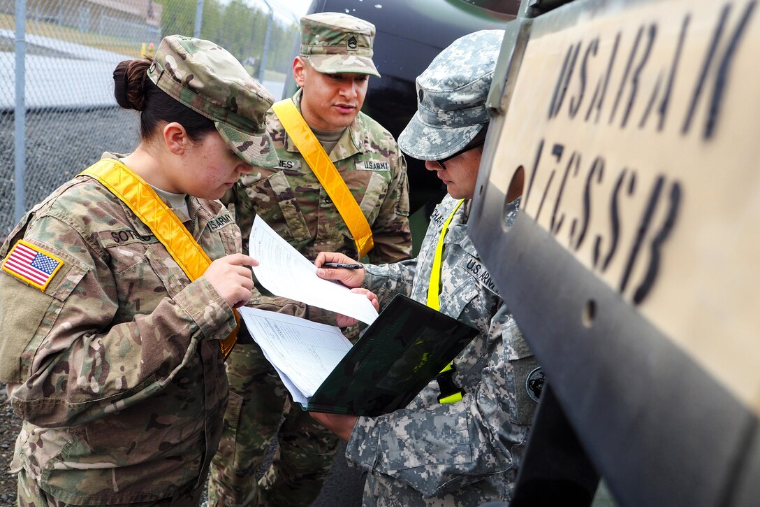 Army Sgt. Selena Sotelo, left, Army Staff Sgt. Rudy Flores, center, and Spc. Sanjeev Acharya review a checklist while performing maintenance on vehicles at Joint Base Elmendorf-Richardson, Alaska, May 9, 2016. Sotelo, Flores and Acharya are assigned to the 17th Combat Sustainment Support Battalion. Air Force photo by Justin Connaher
