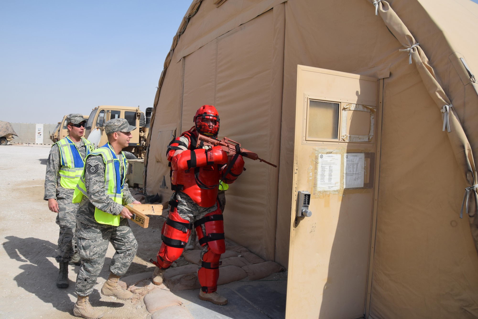 Tech. Sgt. Shawn Rankins, 379th Expeditionary Security Forces Squadron Check Six Team, begins an active shooter exercise with Army Soldiers May 5, 2016, at Al Udeid Air Base, Qatar. Staff Sgt. Joseph Brock, also from the 379th ESFS, portrayed the shooter and wore a red padded suit to protect himself from Soldiers’ physical retaliation as Tech. Sgt. Scott Carpenter, 379th ESFS, strikes two pieces of wood together to simulate gun shots. Check Six teaches Airmen to be aware of their surroundings at all times, and most importantly how to defend themselves and others in the event a hostile threat occurs. (U.S. Air Force photo by Technical Sgt. Carlos J. Trevino/Released)