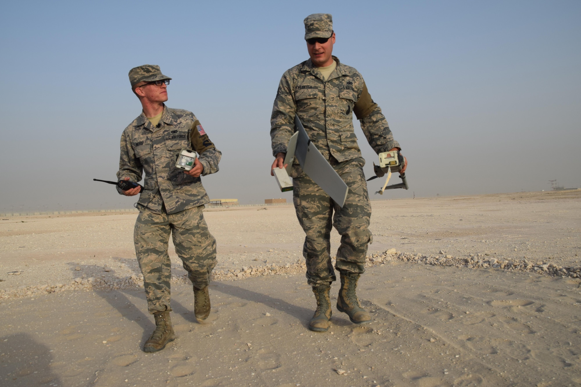 Airman 1st Class Christian Weiss, 379th Expeditionary Security Forces Squadron Raven B unmanned aircraft system operator, and Tech. Sgt. Christopher Pfeiffer pick up the pieces of their Raven B after it crash lands May 5, 2016 at Al Udeid Air Base, Qatar.  Airman Weiss and Tech. Sgt. Pfeiffer are part of a two man crew that fly the unmanned aircraft system. (U.S. Air Force photo by Technical Sgt. Carlos . Trevino)