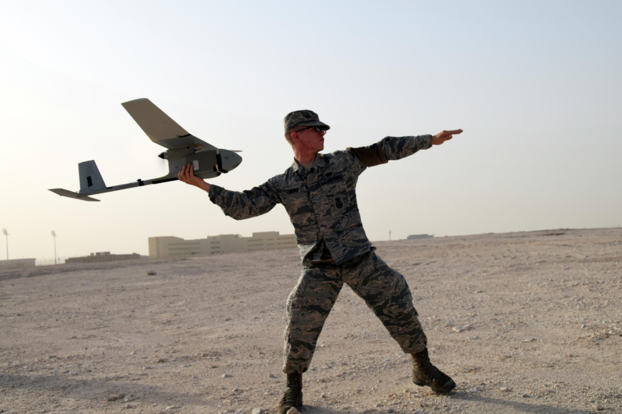 With the aircraft’s engine running, Airman 1st Class Christian Weiss, 379th Expeditionary Security Forces Squadron RQ-11B Raven unmanned aircraft system operator, hand-launches his aircraft May 5, 2016, at Al Udeid Air Base, Qatar.  Airman Weiss is member of a two-person crew that flies the Raven-B to enhance security patrols around the base. (U.S. Air Force photo by Technical Sgt. Carlos J. Trevino)