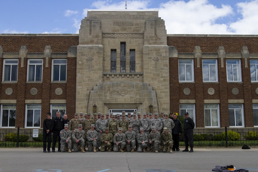 U.S. Army Reserve Soldiers assigned to the 303rd Military Police Company and staff from the Charles Egeler Reception and Guidance Center gather for a photo in Jackson, Michigan, May 14. Corrections officer trainers at the local facility instructed the Soldiers on inmate control procedures. The training is in place to augment their detainee operations in preparation for an upcoming deployment to Guantanamo Bay, Cuba. (U.S. Army photo by Sgt. Audrey Hayes)
