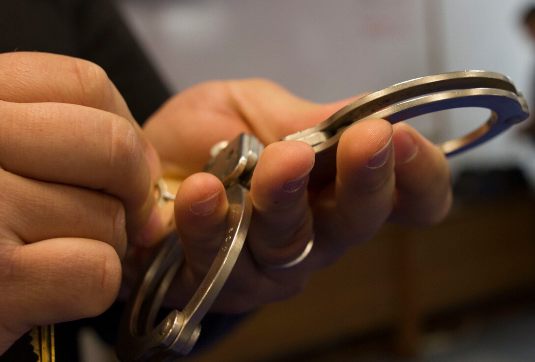 A corrections officer at the Charles Egeler Reception and Guidance Center instructs U.S. Army Reserve Soldiers assigned to the 303rd Military Police Company the first step in applying handcuffs: making sure the locks work. The training occurred in Jackson, Michigan, May 15. The Soldiers were taught inmate control by corrections officer trainers at the local facility. The training is in place to augment their detainee operations in preparation for an upcoming deployment to Guantanamo Bay, Cuba. (U.S. Army photo by Sgt. Audrey Hayes)