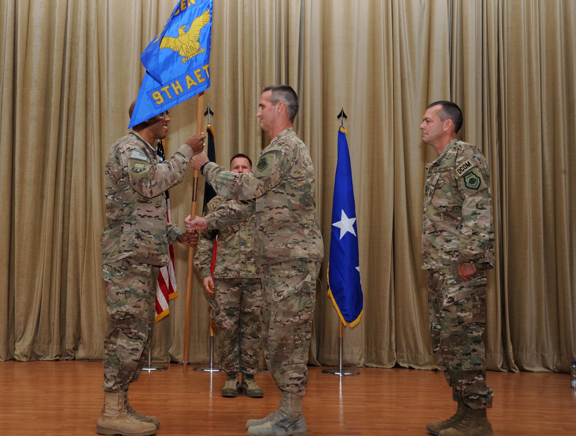 Maj. Gen. Peter Gersten relinquishes command of the 9th Air Expeditionary Task Force-Levant and passes the guidon to Lt. Gen. Charles Brown Jr., U.S. Air Forces Central Command commander, during a change of command ceremony at an undisclosed location in Southwest Asia May 16, 2016. The 9 AETF-L was established on May 18, 2015 in direct support of Combined Joint Task Force – Operation Inherent Resolve. (U.S. Air Force photo by Senior Airman Zachary Kee/Released)