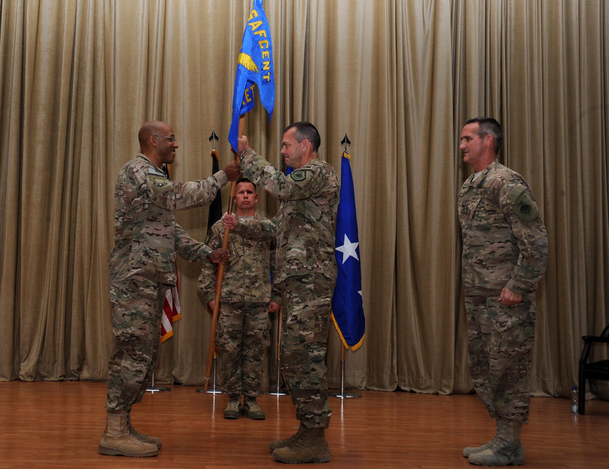 Maj. Gen. Scott Kindsvater assumes command of the 9th Air Expeditionary Task Force-Levant and receives the guidon from Lt. Gen. Charles Brown Jr., U.S. Air Forces Central Command commander, during a change of command ceremony at an undisclosed location in Southwest Asia May 16, 2016. The 9 AETF-L was established on May 18, 2015 in direct support of Combined Joint Task Force – Operation Inherent Resolve.(U.S. Air Force photo by Senior Airman Zachary Kee)