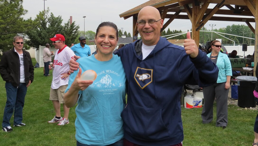 Gina Vasquez, Subsistence director of supplier operations and Rich Faso, Subsistence deputy director, pose after winning both the egg race and water balloon toss May 11 at a Spring Fling event. The Subsistence sensing team hosted the event.