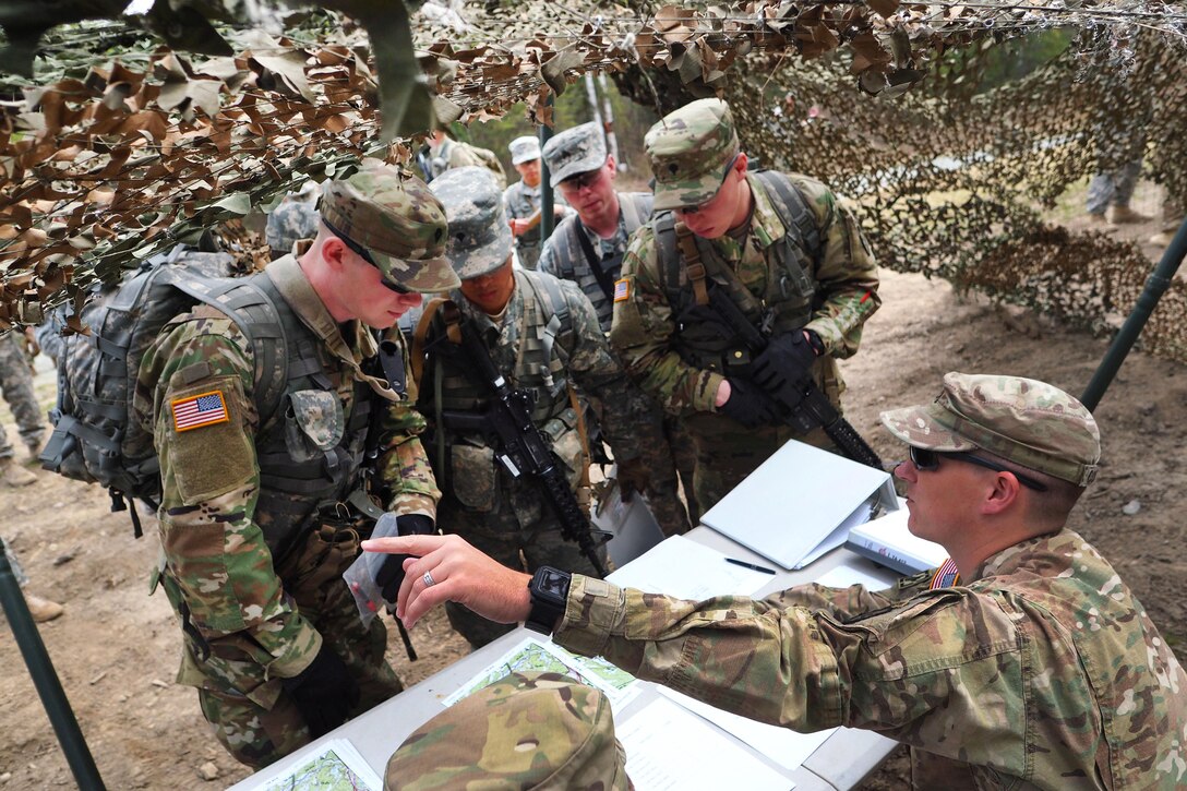 Army Staff Sgt. Cody Coughlin, right, instructs soldiers participating in the land navigation portion of the Best Warrior Competition at Joint Base Elmendorf-Richardson, Alaska, May 3, 2016. Coughlin is assigned to the 25th Infantry Division’s Company B, 6th Brigade Engineer Battalion, 4th Infantry Brigade Combat Team, Alaska. Air Force photo by Justin Connaher
