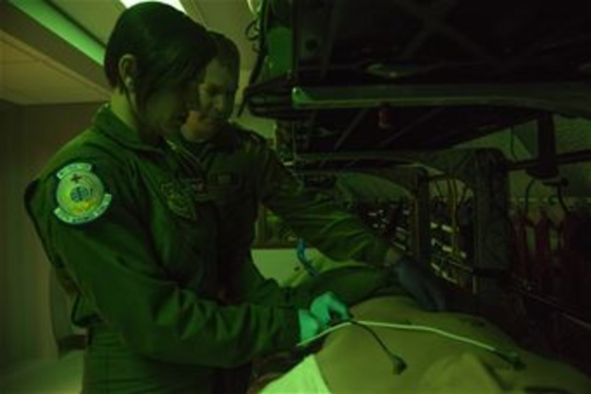 Staff Sgt. Dasha Ermanova, 375th Aeromedical Evacuation Squadron aeromedical evacuation technician, and Captain Damien Miller, 375th Aeromedical Evacuation Squadron flight nurse attach ECG leads to a simulated patient in order to assess the electrical activity of the patients heart on a new training simulator at Scott Air Force Base, Illinois on May 5, 2015. The Cargo Compartment Trainer comes equipped with new features including an upgraded camera and recording system which gives the ability to replay training scenarios and document trends. (U.S. Air Force Photo by Airman Daniel Garcia)