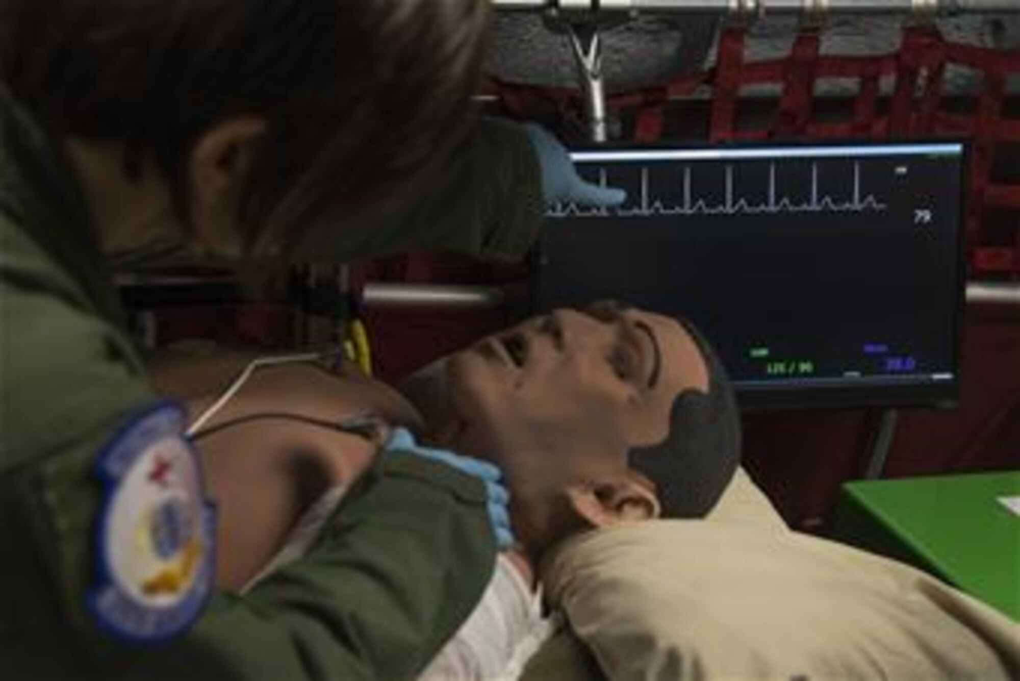 Staff Sgt. Dasha Ermanova, 375th Aeromedical Evacuation Squadron aeromedical evacuation technician, assess a simulated patient's responsiveness while comparing the results on a vitals monitor on a new training simulator at Scott Air Force Base, Illinois on May 5, 2015. The Cargo Compartment Trainer comes equipped with new features including an upgraded camera and recording system which gives the ability to replay training scenarios and document trends. (U.S. Air Force Photo by Airman Daniel Garcia)