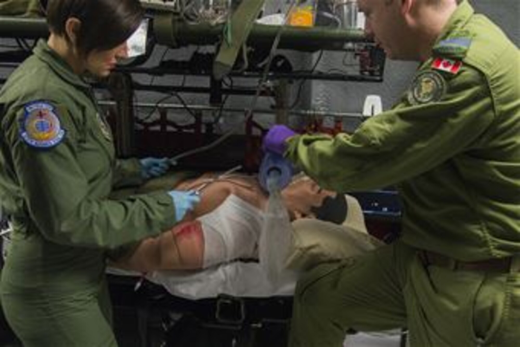 Capt. Damien Miller, 375th Aeromedical Evacuation Squadron flight nurse, provides rescue breaths to a simulated patient who is having difficulties breathing while Staff. Sgt. Dasha Ermanova is prepared to suction the patient if required on a new training simulator at Scott Air Force Base, Illinois on May 5, 2016. The Cargo Compartment Trainer comes equipped with new features including an upgraded camera and recording system which gives the ability to replay training scenarios and document trends. The 375th AES completed 117 missions in the year 2015. (U.S. Air Force Photo by Airman Daniel Garcia)