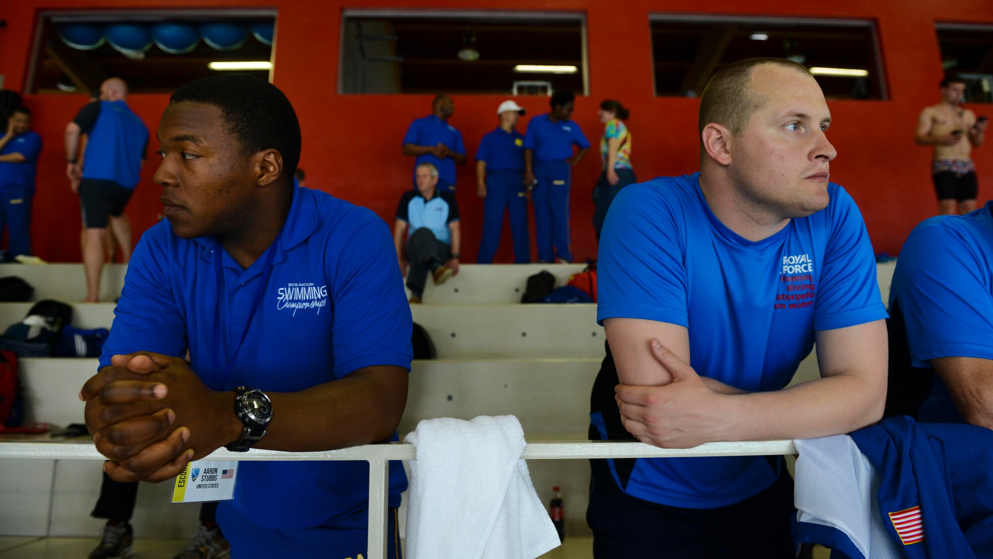 U.S. Air Force Senior Airman Aaron Stubbs, 31st Civil Engineer Squadron emergency management journeyman and, and a British Royal Air Force airman watch their respective teams during the 2016 Headquarters Allied Air Command Swimming Championship, May 12, 2016, in Maniago, Italy. The event brought together six nations from HQ AIRCOM in the spirit of friendly sporting competition. (U.S. Air Force photo by Senior Airman Austin Harvill/Released)