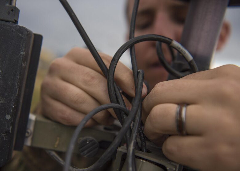1st Lt. Justin D'olimpio, 455th Expeditionary Operations Support Squadron weather flight commander, connects wires back into a Tactical Meteorological Observation System or TMQ-53 at Bagram Airfield, Afghanistan, May 16, 2016. Members of the 455th EOSS/OSW provide timely and accurate weather forecasts for aircrews, allowing flying units to plan and adjust mission requirements accordingly.(U.S. Air Force photo by Senior Airman Justyn M. Freeman)