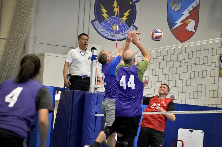 22nd Space Operations Squadron members Korey Kuykendall (left) and John Baldwin (right) block a hit from John Thien during the intramural volleyball championship game against the U.S. Air Force Warfare Center at the Schriever Air Force Base, Colorado, fitness center, Wednesday, May 11, 2016. The USAFWC won the championship title for a second straight year, winning in two straight sets. (U.S. Air Force photo/Katie Calvert)