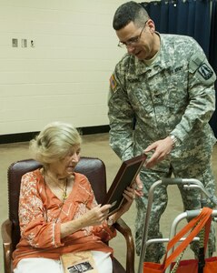 Eva Dukesz Friedlander, a Holocaust survivor, receives a Certificate of Appreciation from Col. Lon E. Sunshine, the 335th Signal Command (Theater) Chief of Staff, on behalf of the unit May 14, 2016 at East Point, Georgia. Friedlander shared her life story and how she survived the Holocaust with more than 100 Soldiers who attended the Holocaust Day of Remembrance. During the 335th SC(T) battle assembly weekend, the Equal Opportunity Office conducted its annual observance of the National Day of Remembrance, which was established by Congress in 1980 to ensure the victims of the Holocaust are remembered forever. (U.S. Army photo by Sgt. Stephanie A. Hargett)