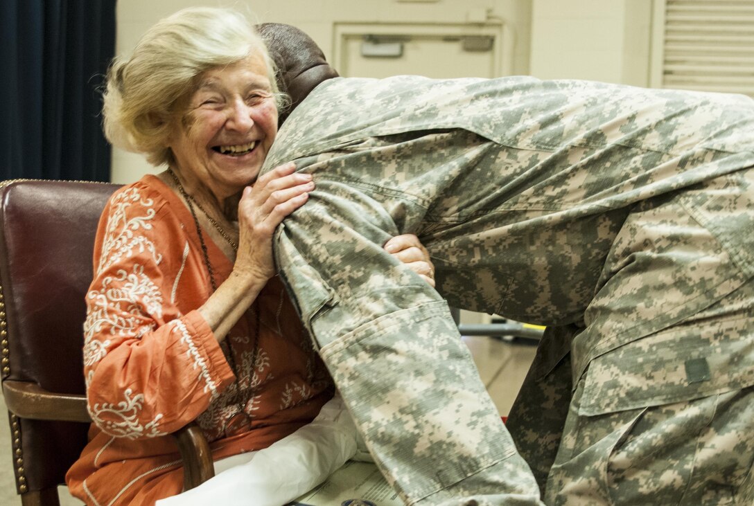 Eva Dukesz Friedlander, a Holocaust survivor, receives a hug from a 335th Signal Command (Theater) Soldier who attended the Holocaust Day of Remembrance May 14, 2016 at East Point, Georgia. Friedlander spoke with Soldiers one on one after the event allowing them to ask questions. During the 335th SC(T) battle assembly weekend, the Equal Opportunity Office conducted its annual observance of the National Day of Remembrance, which was established by Congress in 1980 to ensure the victims of the Holocaust are remembered forever. (U.S. Army photo by Sgt. Stephanie A. Hargett)