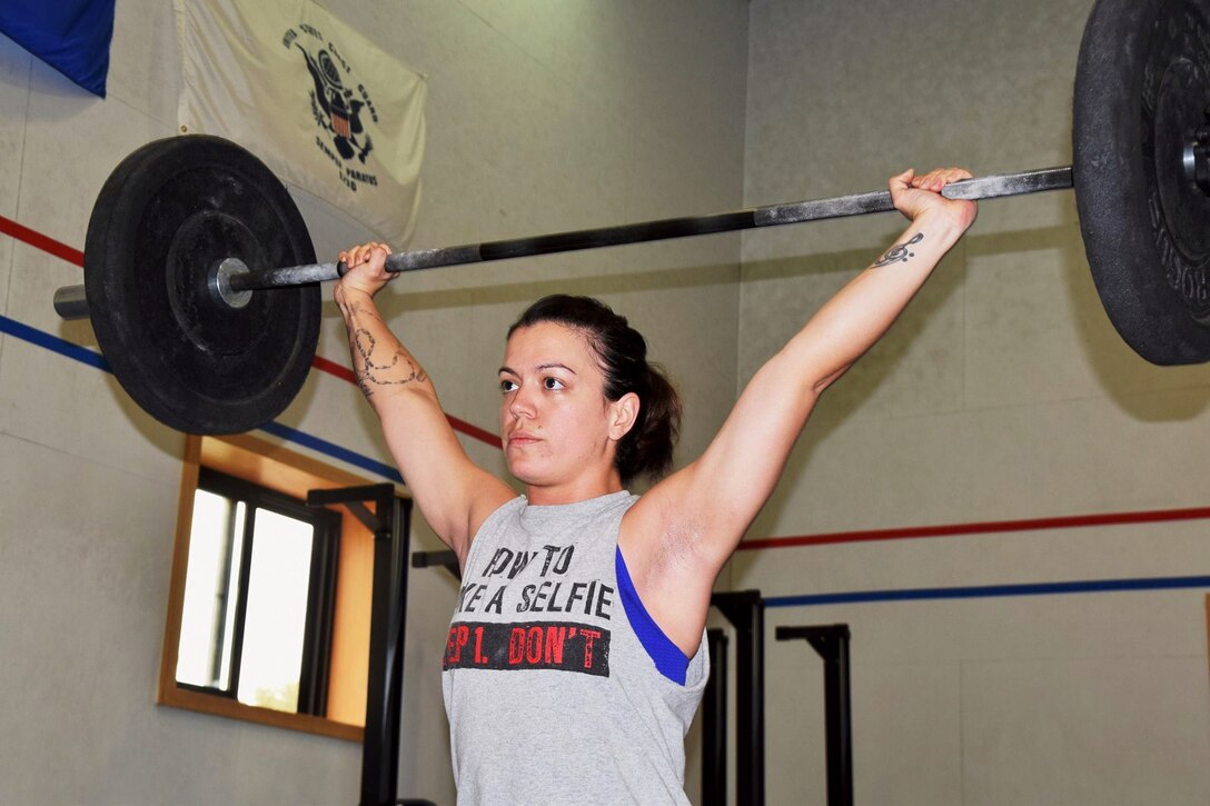 Army Sgt. Julienne Ashby, former 35th Air Defense Artillery Brigade property book noncommissioned officer-in-charge, raises a barbell over her head during a CrossFit competition at Camp Humphreys, South Korea, Sept. 12, 2015. Ashby, a native of Casa Grande, Ariz., took third place in the event. Ashby encourages her fellow soldiers to maintain their physical fitness. Courtesy photo