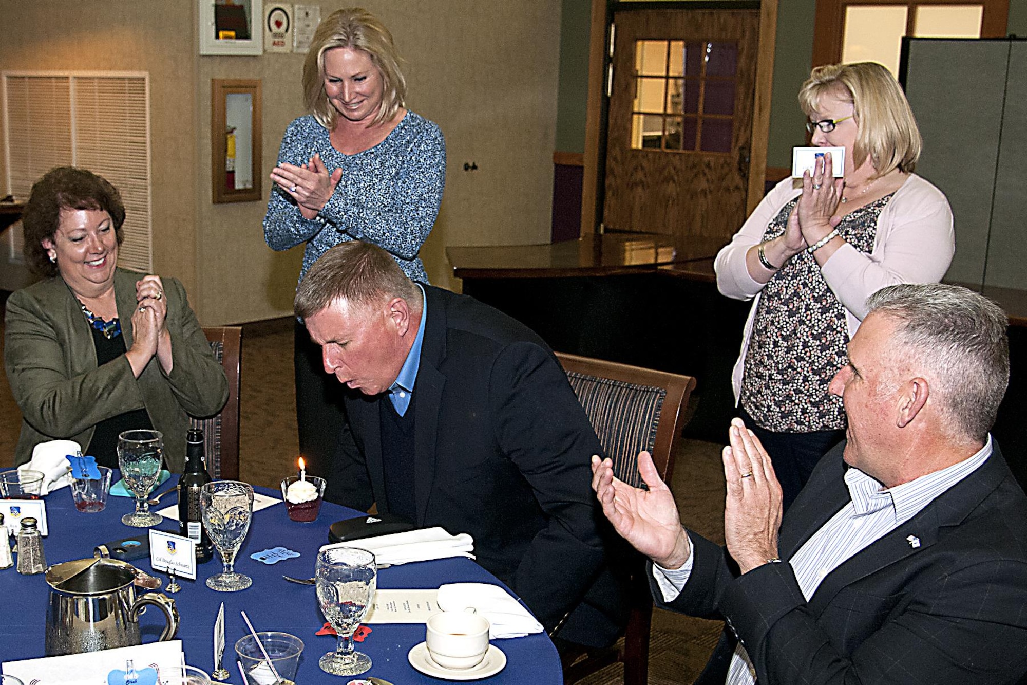 Col. Doug Schwartz, 434th Air Refueling Wing commander, blows out a candle while friends and family sing happy birthday May 14, 2016 at Grissom Air Reserve Base, Ind. The birthday celebration was sprung on him during his retirement dinner celebrating over 35 years of military service. (U.S. Air Force photo/Senior Airman Dakota Bergl) 