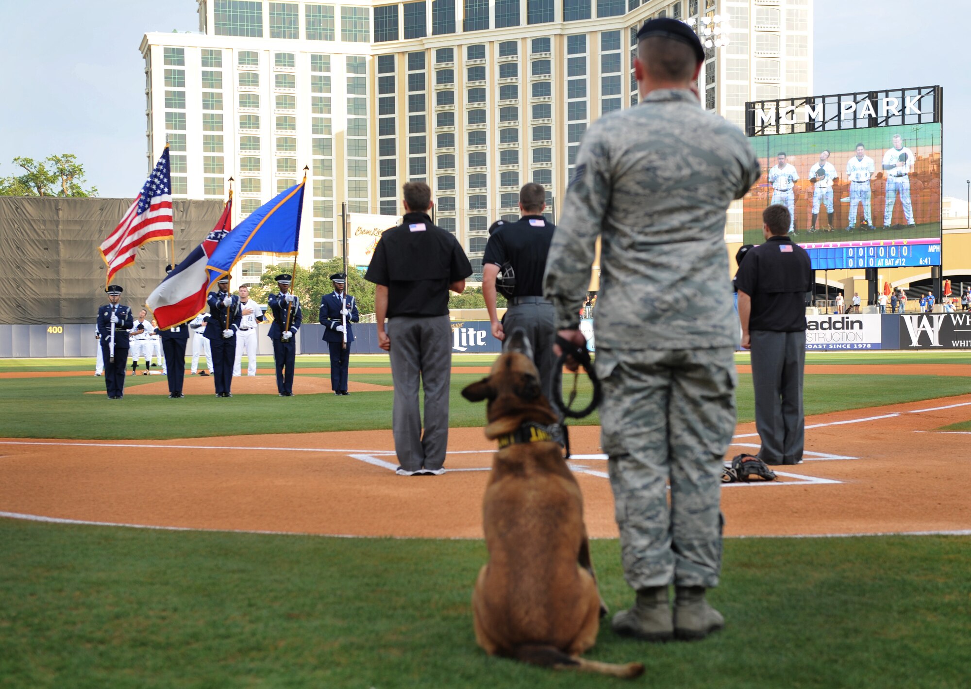 Tech. Sgt. James Martin, 81st Security Forces kennel master, renders a salute with his military working dog, Densy, at the MGM Park during a Biloxi Shuckers Minor League Baseball team pre-game ceremony May 9, 2016. The “Bark in the Park” themed baseball game invited fans to sit in the outfield seating area with their dogs. (U.S. Air Force photo by Kemberly Groue)