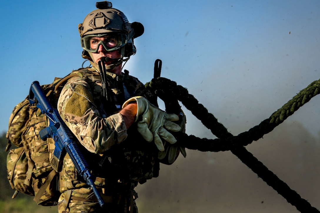 An airman pulls on a rope from a hovering Army UH-60 Black Hawk helicopter during Emerald Warrior 16 at Hurlburt Field, Fla., May 4, 2016. Air Force photo by Senior Airman Trevor T. McBride