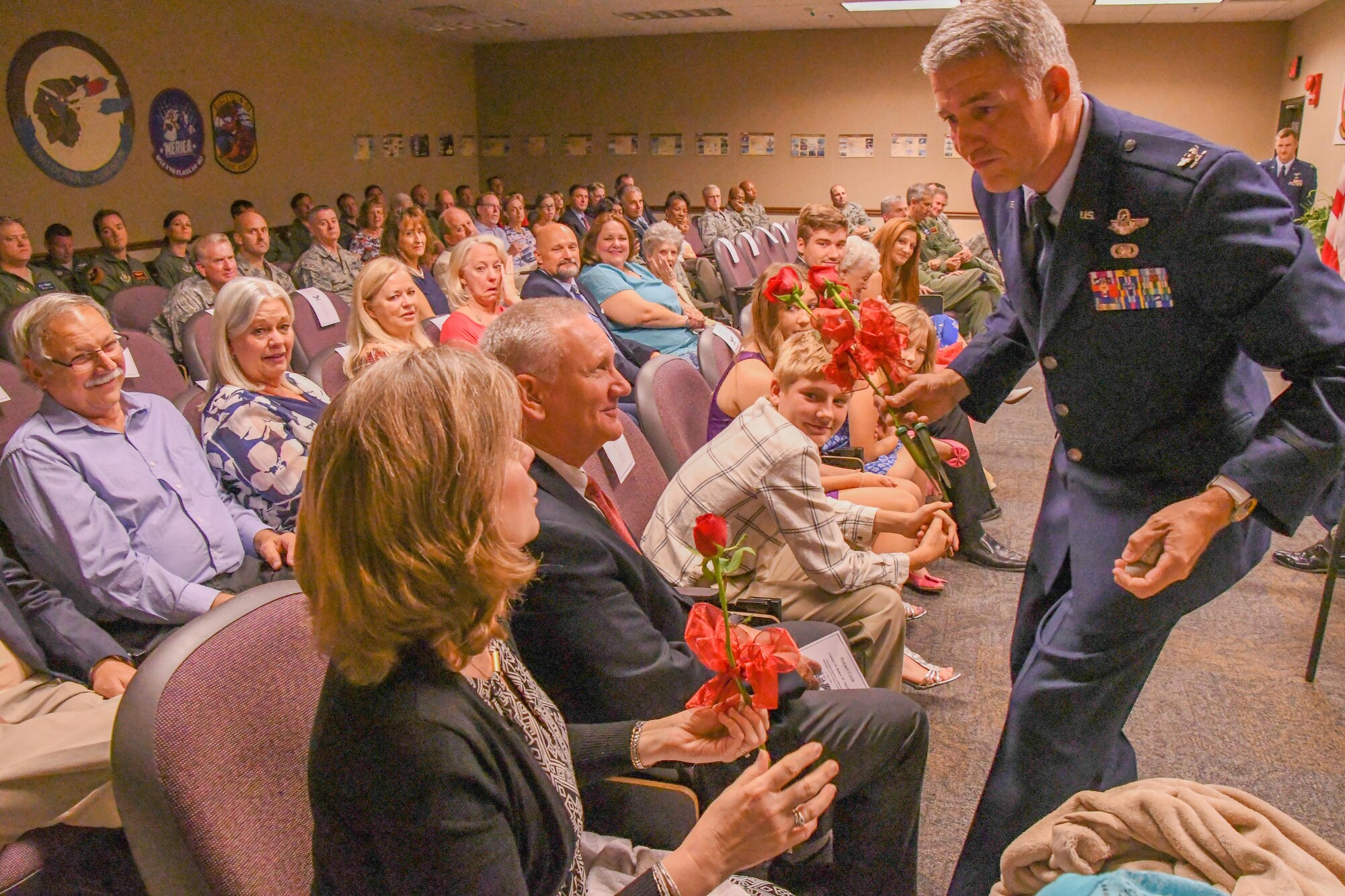 U.S. Air Force Col. Robert VanHoy, the 93rd Bomb Squadron commander, presents one of his sisters with a rose during his promotion ceremony. VanHoy is promoted to the rank of colonel in a ceremony attended by his family and friends at Barksdale Air Force Base, La. on May 15, 2016. (U.S. Air Force photo by Master Sgt. Dachelle Melville/Released)
