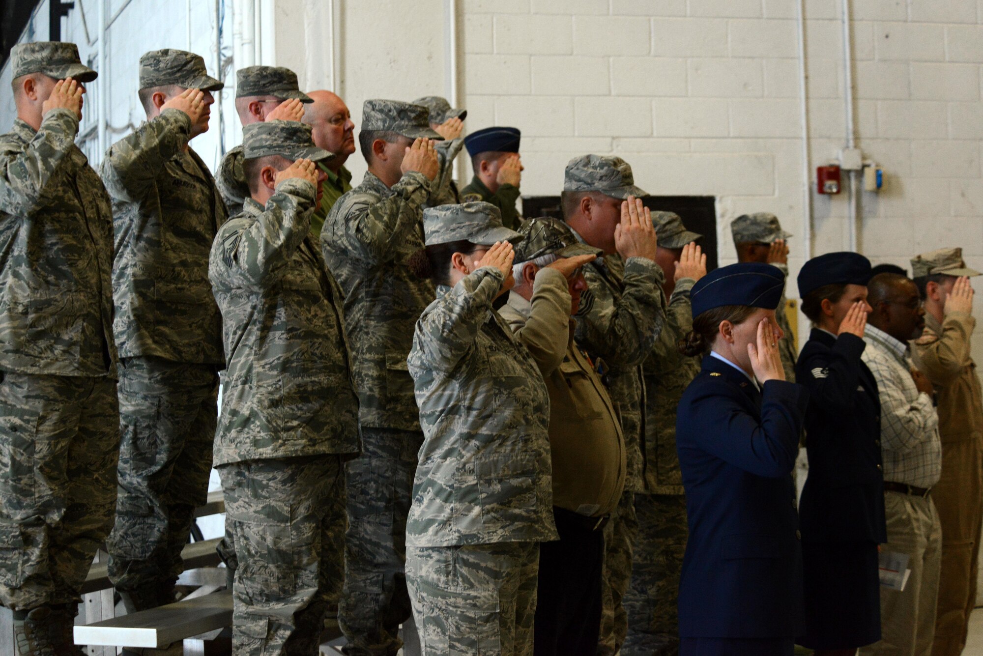 U.S. Airmen salute the flag during the playing of the national anthem at a change of command ceremony at Shaw Air Force Base, S.C., May 17, 2016. Maj. Gen. Mark Kelly relinquished command of the Ninth Air Force to Maj. Gen. Scott Zobrist in a change of command ceremony officiated by Gen. Hawk Carlisle, Air Combat Command commander. (U.S. Air Force photo by Airman 1st Class Kelsey Tucker)