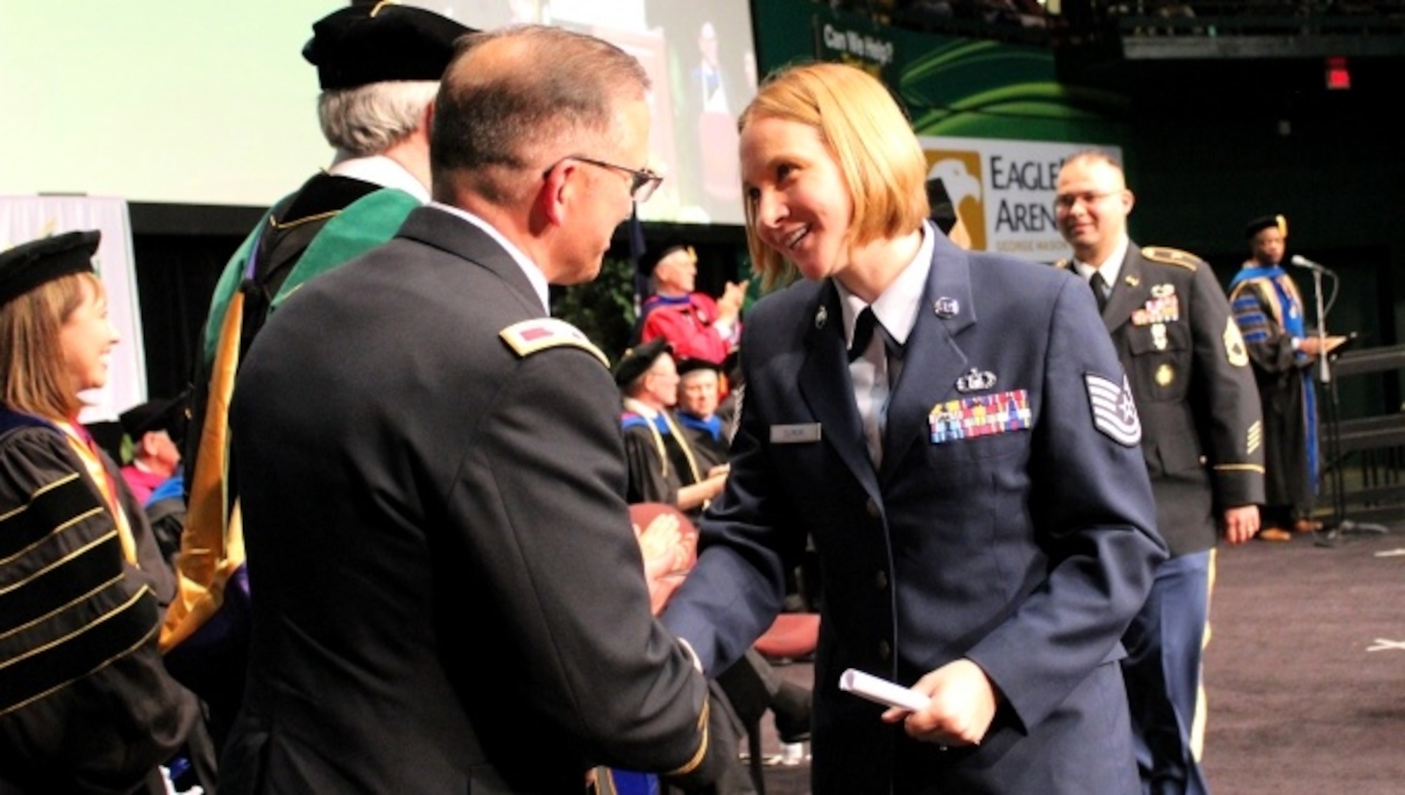 Tech. Sgt. Lindsay Slimski, the first and only female member of the Enlisted to Medical Degree Preparatory Program, crosses the stage at a commencement ceremony held at George Mason University on May 11, 2016, as she graduates from the Enlisted to Medical Degree Preparatory Program. The Enlisted to Medical Degree Preparatory Program is a partnership between the Armed Services and Uniformed Services University. Designed for enlisted service members, the two-year program enables members to remain on active duty status while enrolled as full-time students in preparation for application to medical school. (U.S. Air Force photo by Prerana Korpe, AFMS Public Affairs)