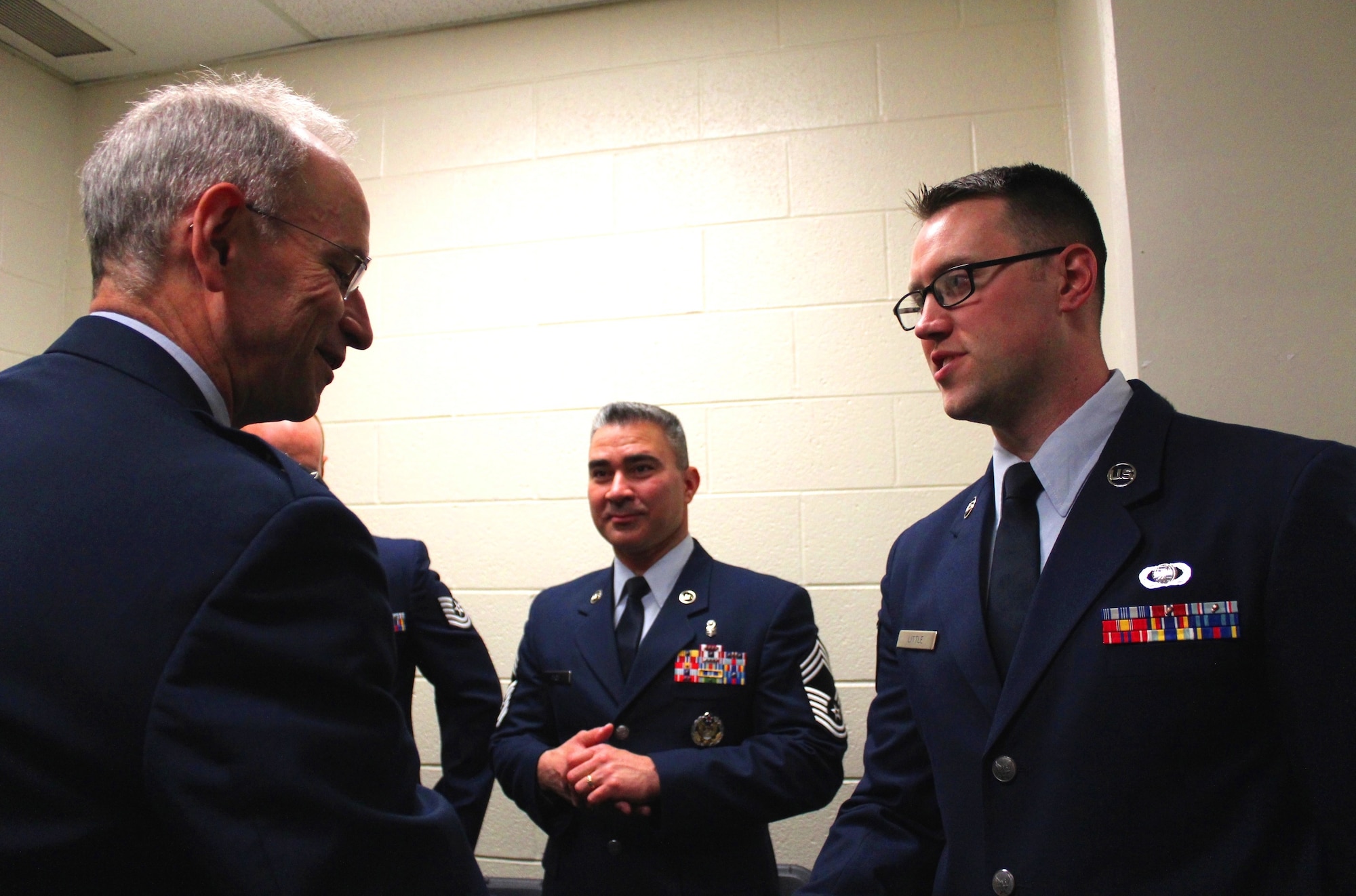 Air Force Surgeon General Lt. Gen. (Dr.) Mark Ediger (left) coins EMDP2 student Staff Sgt. Matt Little (right) during a backstage meeting prior to the commencement ceremony. The charter class of the Enlisted to Medical Degree Preparatory Program graduated on May 11, 2016 during a commencement ceremony held at George Mason University. The Enlisted to Medical Degree Preparatory Program is a partnership between the Armed Services and Uniformed Services University. Designed for enlisted service members, the two-year program enables members to remain on active duty status while enrolled as full-time students in preparation for application to medical school. (U.S. Air Force photo by Prerana Korpe, AFMS Public Affairs)