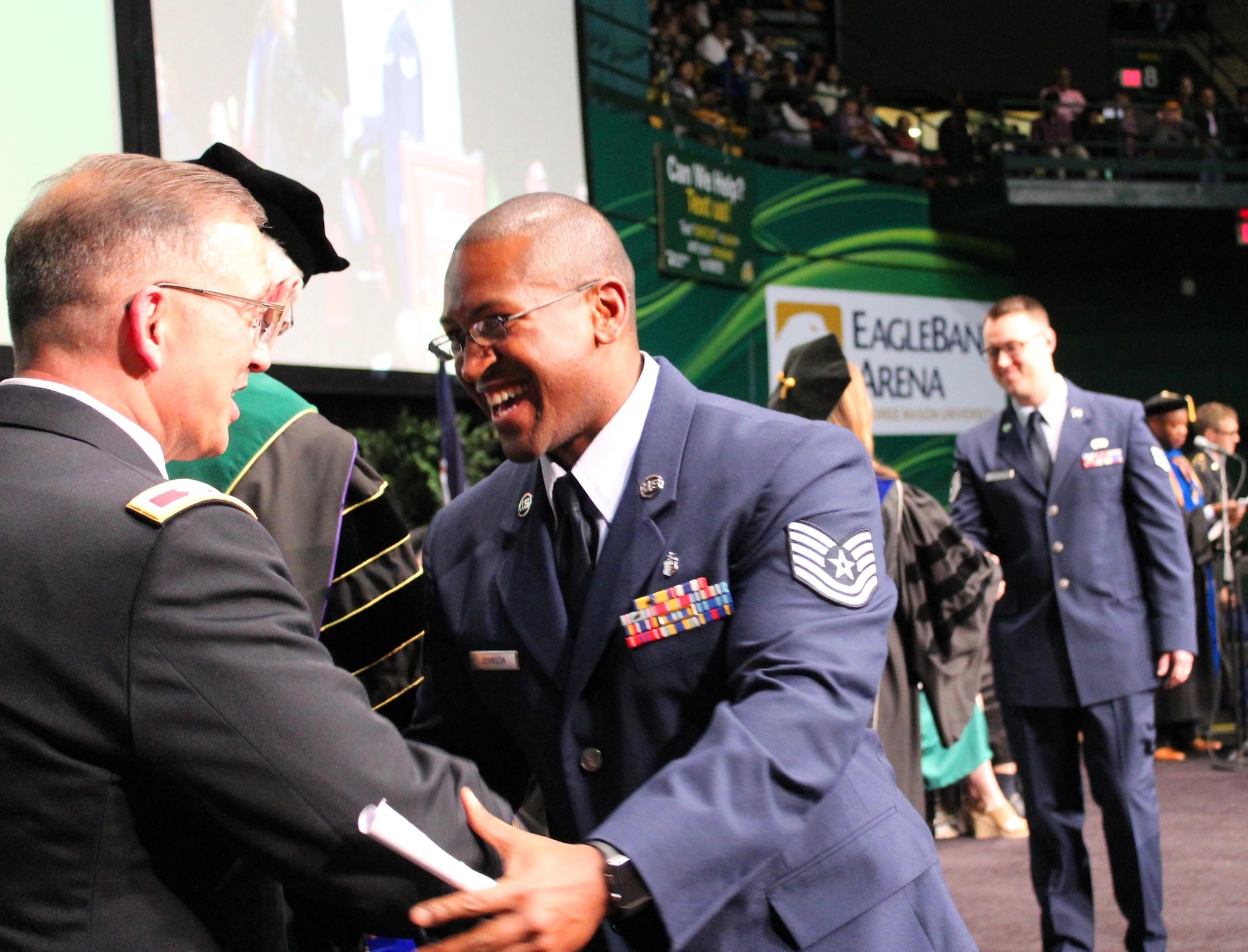 Tech. Sgt. Kenneth Johnson crosses the stage at a commencement ceremony held at George Mason University on May 11, 2016, as he graduates from the Enlisted to Medical Degree Preparatory Program. The Enlisted to Medical Degree Preparatory Program is a partnership between the Armed Services and Uniformed Services University. Designed for enlisted service members, the two-year program enables members to remain on active duty status while enrolled as full-time students in preparation for application to medical school. (U.S. Air Force photo by Prerana Korpe, AFMS Public Affairs)