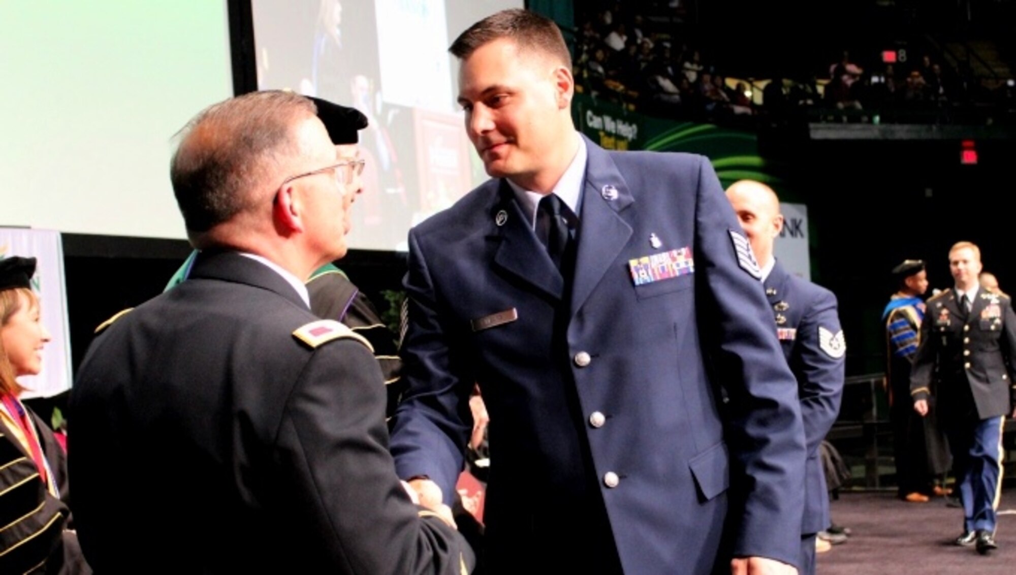 Tech. Sgt. Jeremy Mears crosses the stage at a commencement ceremony held at George Mason University on May 11, 2016, as he graduates from the Enlisted to Medical Degree Preparatory Program. The Enlisted to Medical Degree Preparatory Program is a partnership between the Armed Services and Uniformed Services University. Designed for enlisted service members, the two-year program enables members to remain on active duty status while enrolled as full-time students in preparation for application to medical school. (U.S. Air Force photo by Prerana Korpe, AFMS Public Affairs)