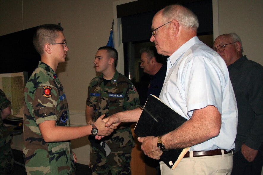 Allan Parkhurst, an Army veteran, shakes the hand of Civil Air Patrol (CAP) cadet Jonathan Meals here, April 18. Bob and his brother Allan Parkhurst, an Army veteran, who were both awarded the Distinguished Flying Cross for their service in the Vietnam War, came to a CAP meeting to tell their story to the cadets. The Civil Air Patrol is an auxiliary of the United States Air Force with the mission to provide aersospace education, cadet programs and emergency services. (U.S. Air Force photo/Maj. Polly Orcutt)