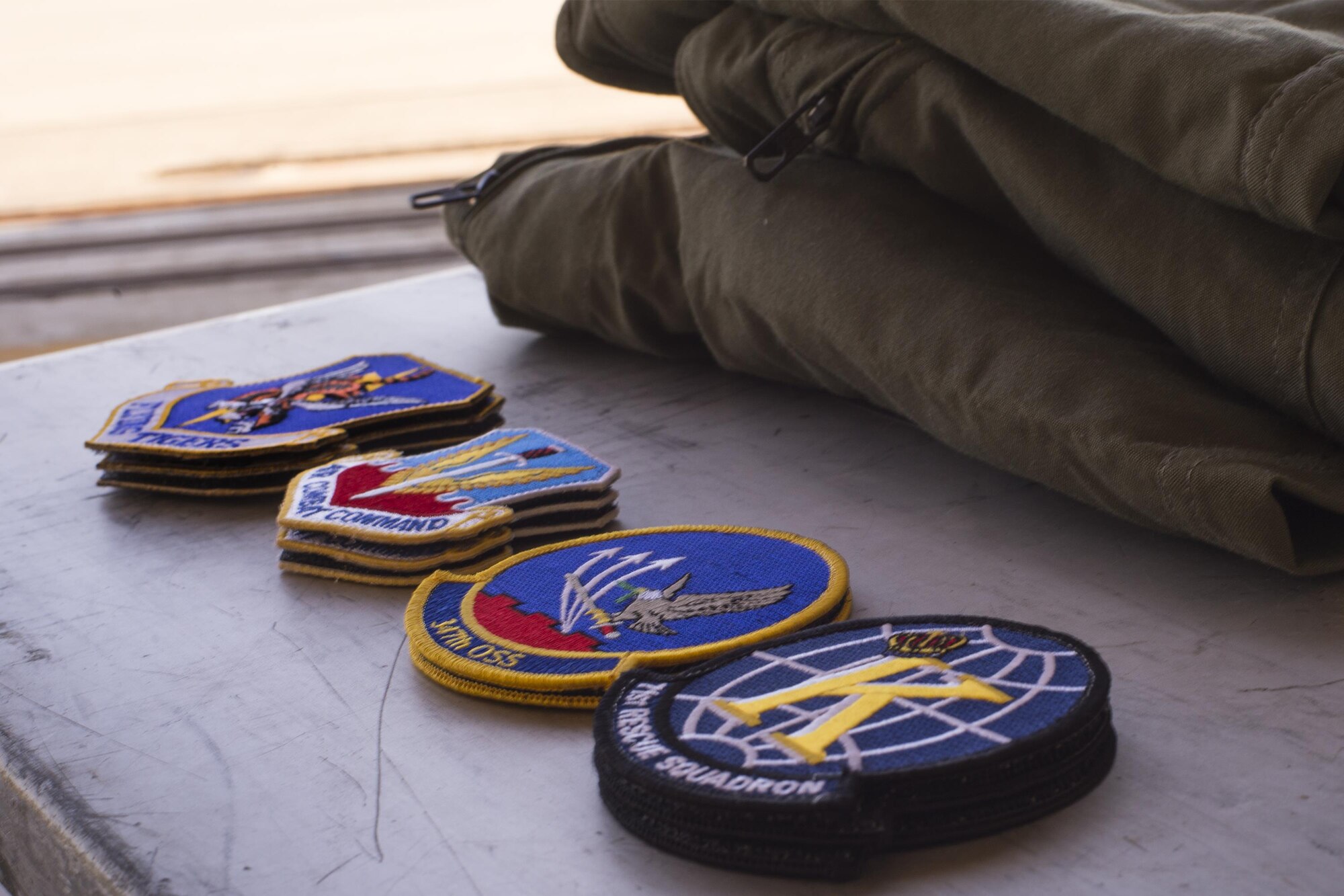 U.S. Air Force patches rest beside folded flight suits during a spouses’ flight event, May 13, 2016, at Moody Air Force Base, Ga. Family members of 347th Rescue Group Airmen had the opportunity to get their photo taken wearing a flight suit and patches of their choice. (U.S. Air Force photo by Airman Daniel Snider/Released)