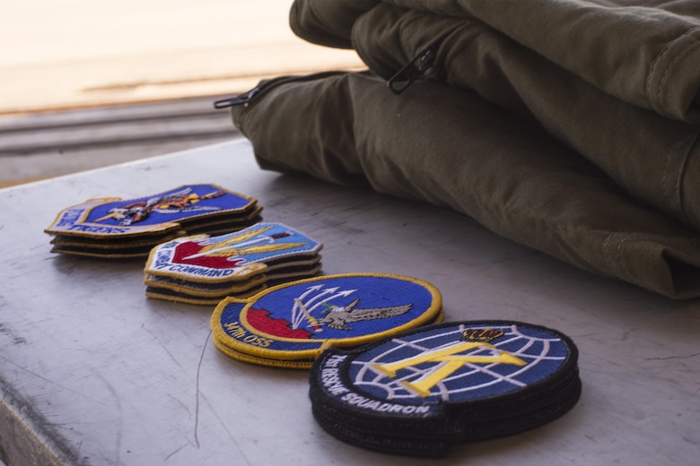 U.S. Air Force patches rest beside folded flight suits during a spouses’ flight event, May 13, 2016, at Moody Air Force Base, Ga. Family members of 347th Rescue Group Airmen had the opportunity to get their photo taken wearing a flight suit and patches of their choice. (U.S. Air Force photo by Airman Daniel Snider/Released)