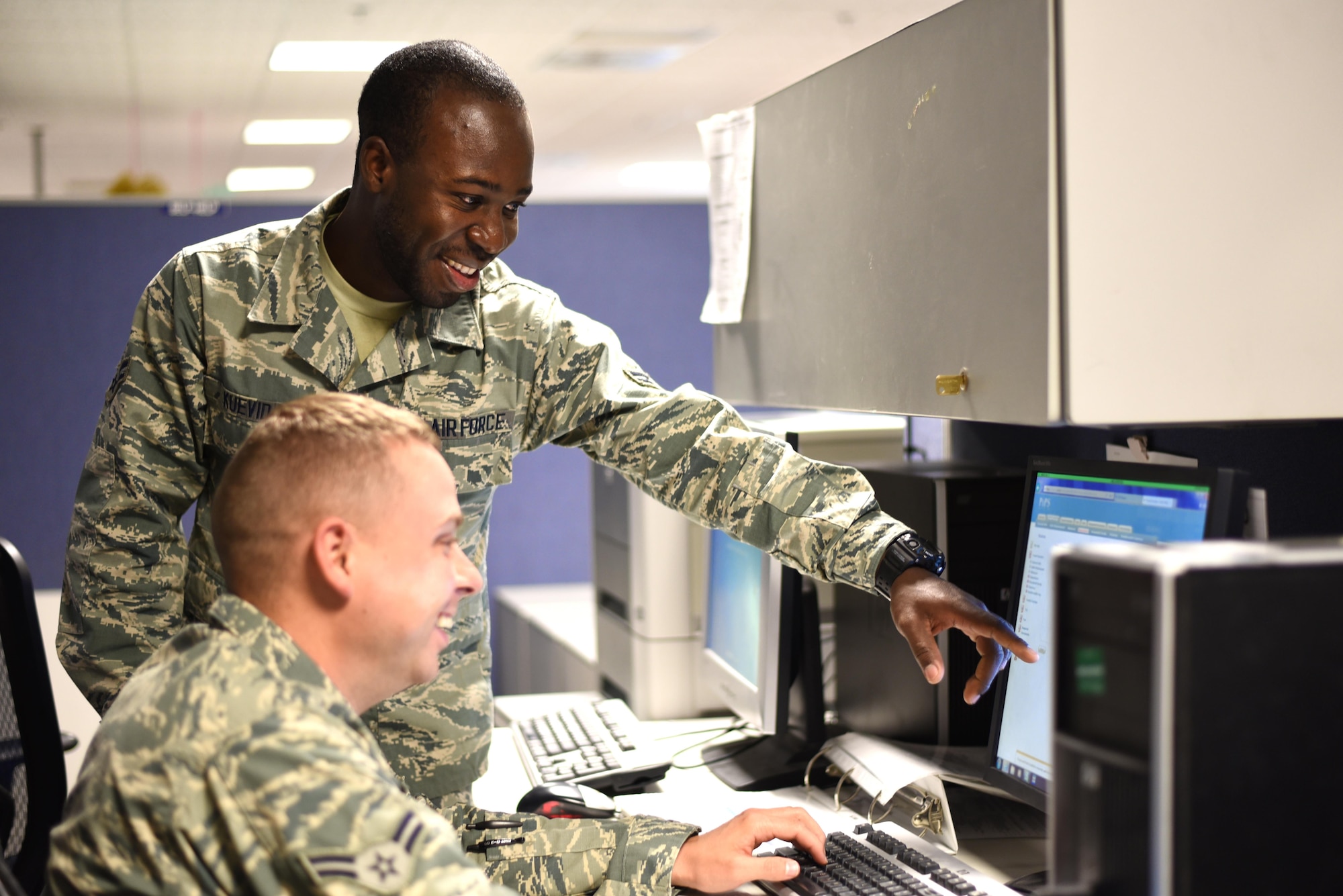 Airman 1st Class Folly Kuevidjin, a 21st Comptroller Squadron financial management specialist, helps a customer with financial questions at Peterson Air Force Base, Colo., on May 17, 2016. On average, Kuevidjin helps around 30 customers a day. (U.S. Air Force photo by Airman 1st Class Dennis Hoffman)