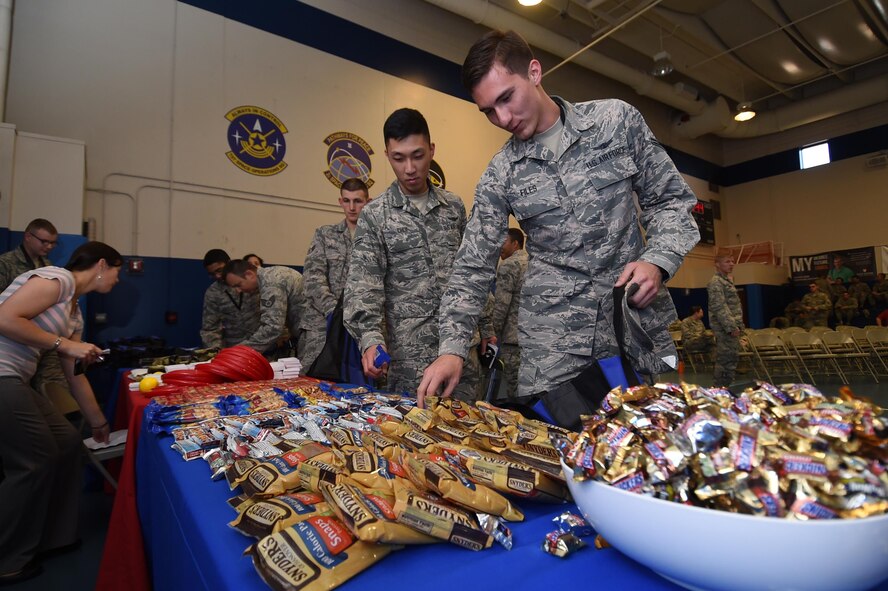Schriever Airmen grab snacks and giveaways during the Wingman University pep rally at Schriever Air Force Base, Colorado, Thursday, May 12, 2016. Students were able to take their snacks and supplies with them throughout the day to all of their classes and activities. (U.S. Air Force photo/2nd Lt. Darren Domingo)