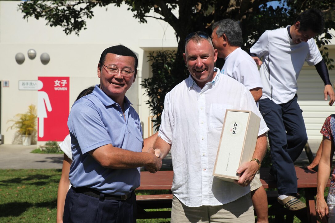 Hajime Nakama, the Kin town mayor, shakes hands with Col. Sean M. McBride, the commanding officer of III Marine Headquarters Group May 14 at the Nature Mirai-kan in Kin town. McBride joined Nakama for a barbecue lunch and the two discussed the good relationships between the local community and service members in Kin town.