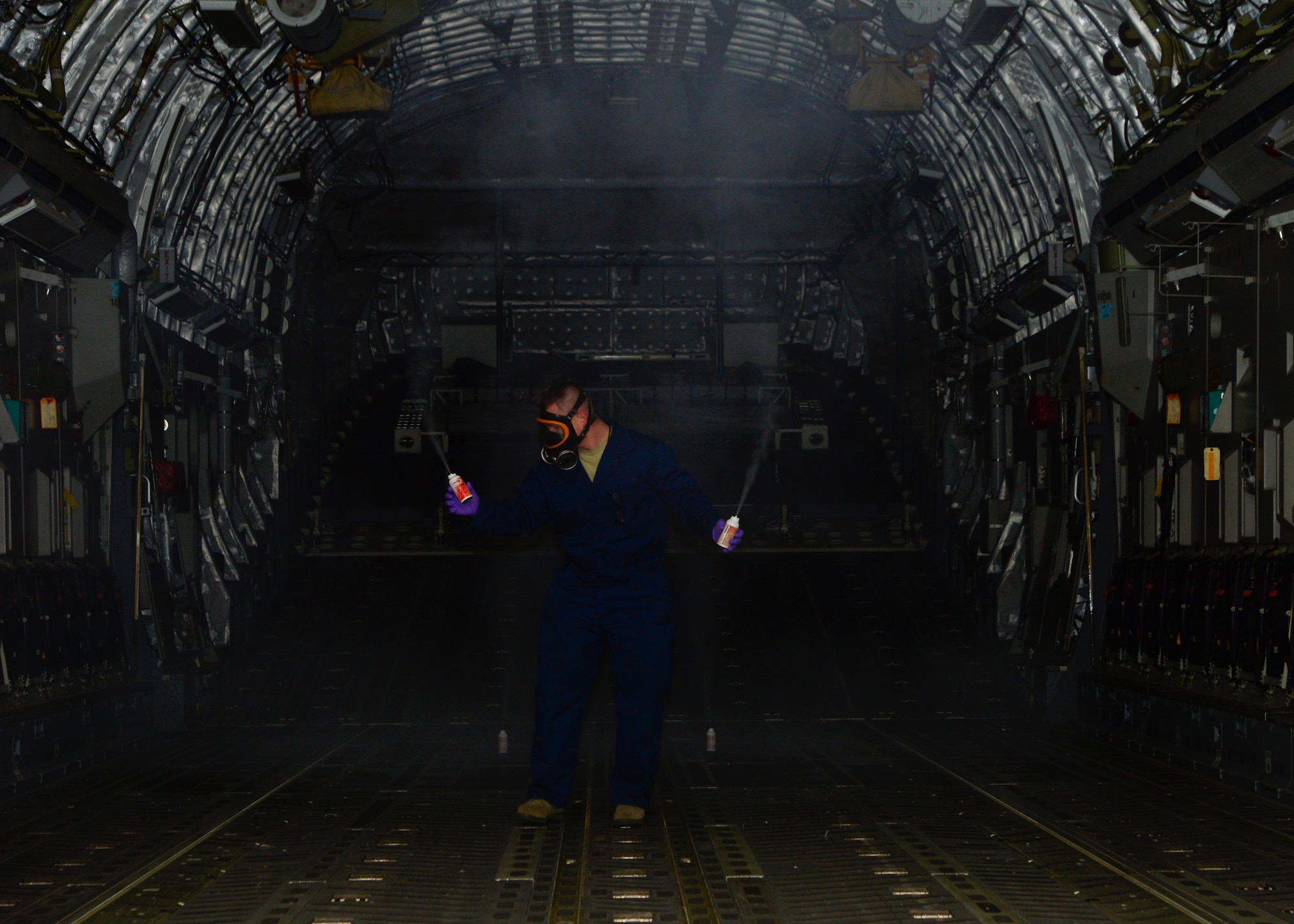 Staff Sgt. Daniel Fink, 436th Civil Engineer Squadron Pest Management supervisor, places aerosol fog canisters of Callington 1 Shot inside of a C-17 Globemaster III to treat for mosquitos that are potentially carrying the Zika virus May 11, 2016, at Dover Air Force Base, Del. Once the aerosol cans are fully dispensed, the aircraft is sealed for 15-20 minutes so the treatment can take effect. (U.S. Air Force photo/Senior Airman William Johnson)