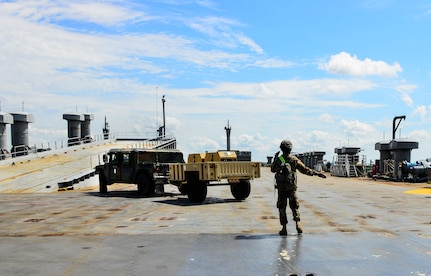 Private First Class Deandre Legacy, a 226th Composite Supply Company mechanic, directs a Humvee on the M/V Cape Decision (AKR-5054) ship during a Sealift Emergency Deployment Exercise at the Joint Base Charleston Federal Law Enforcement Training Center, May 10, 2016. More than 200 soldiers and 100 vehicles from Fort Stewart, Ga. convoyed to JB Charleston for a three-day Sealift Emergency Deployment Exercise. (U.S. Air Force Photo/Airman Megan Munoz)
