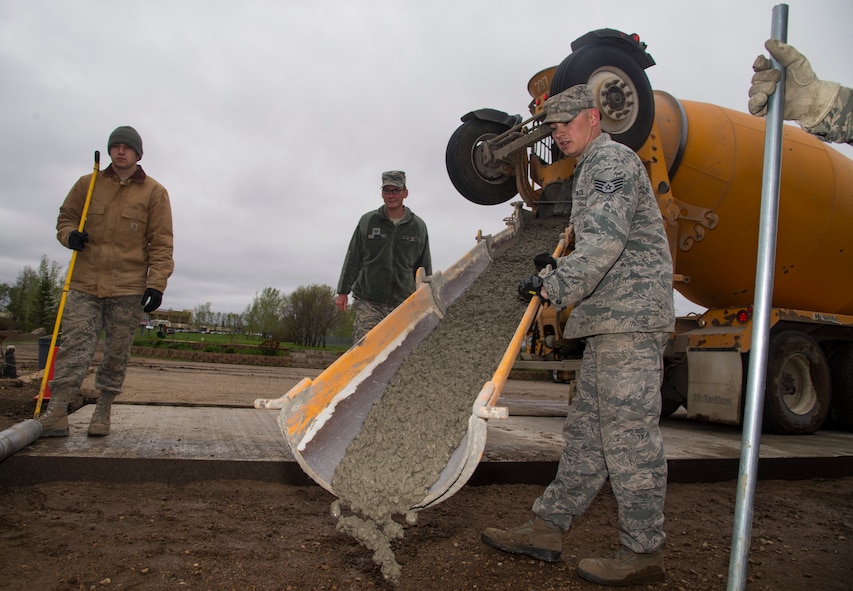 5th Civil Engineer Squadron pavement and equipment members pour concrete at Minot Air Force Base, N.D., May 12, 2016. The pavement and equipment shop or the “dirt boys,” do a variety of jobs around base including concrete, pavement and other repairs. (U.S. Air Force photo/Airman 1st Class Christian Sullivan)